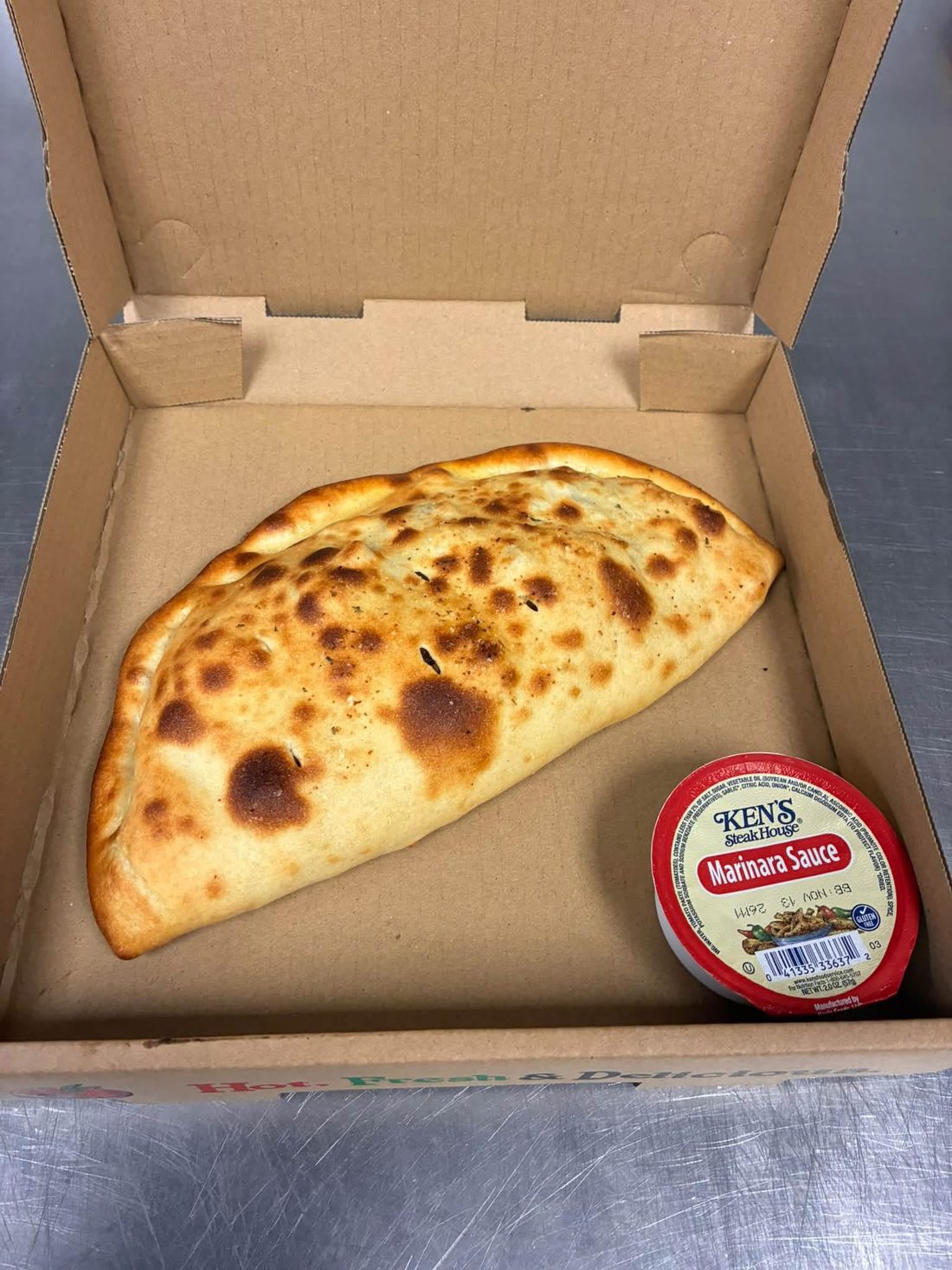 A golden baked calzone with marinara
