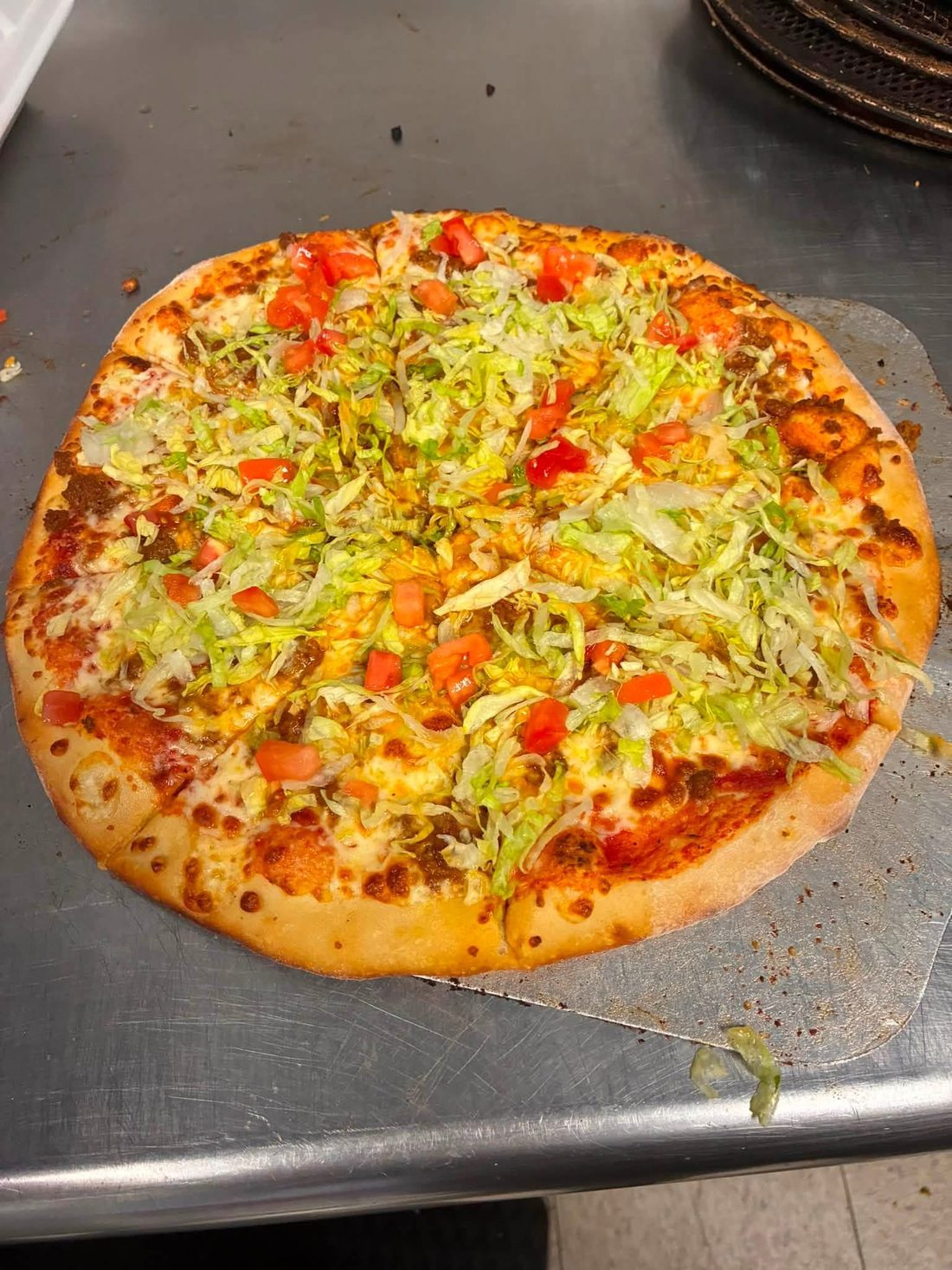 Pizza topped with lettuce and tomato